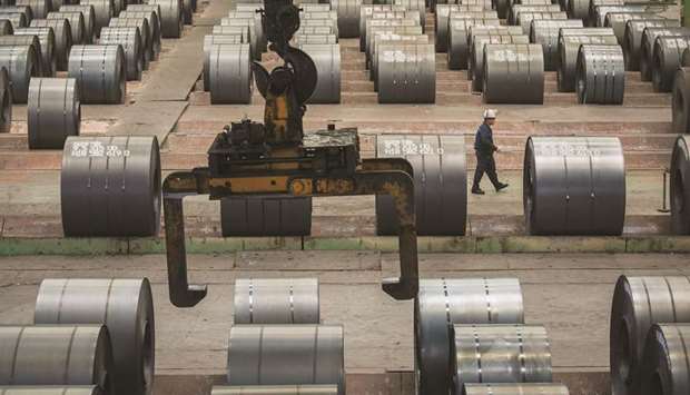 A worker walks past steel rolls at the Chongqing Iron and Steel plant in Changshou, China. A year and a half ago, Chongqing Iron and Steel, Chinau2019s oldest  steelmaker, was rescued from the brink of bankruptcy in a deal hailed as a shining example of how struggling state companies can be revamped.