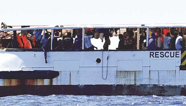 Migrants are seen aboard the Open Arms ship, close to the Italian shore in Lampedusa.