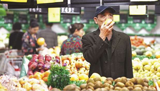 A customer selects fruits at a supermarket in Huaibei, Anhui province. Chinau2019s state planner said yesterday it would roll out a plan to boost disposable income this year and in 2020 to spur private consumption, a major plank in the worldu2019s second-biggest economy.