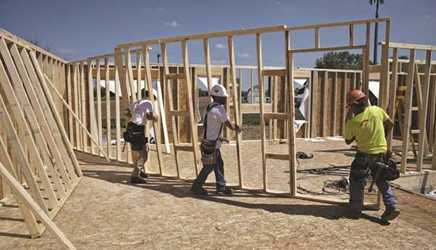 Workers carry a wall frame for a home under construction at a development in Plano, Illinois. Housing starts dropped 4.0% to a seasonally adjusted annual rate of 1.191mn units last month, the Commerce Department said yesterday.