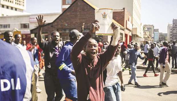A protester holds a copy of the Constitution of Zimbabwe during a demonstration and clashes with the police in Harare, yesterday.