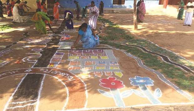 Women drawing a community map using the kolam art form in Ayyampatty in southern state of Tamil Nadu, India.