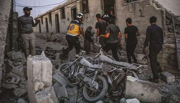 Members of the Syrian Civil Defence, also known as the u201cWhite Helmetsu201d, search for survivors in a collapsed building following a reported air strike in Kfar Ruma in the northwestern Idlib province.