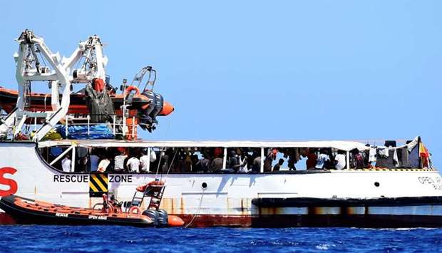 Migrants are seen aboard Spanish migrant rescue ship Open Arms, close to the Italian shore in Lampedusa