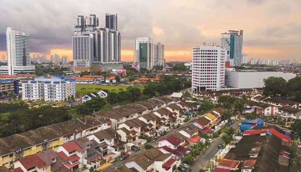 The sun sets beyond residential and commercial buildings in this aerial photograph taken above Johor Bahru, Malaysia.