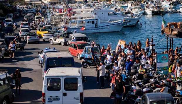Twenty-seven unaccompanied minors leave the harbour in Lampedusa in police vans yesterday.