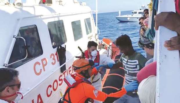 A still image taken from video shows one of the minors, among those stranded on the migrant rescue ship Open Arms, disembark in Lampedusa, Italy.