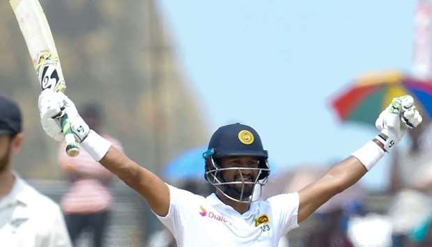 Sri Lanka's cricket team captain Dimuth Karunaratne (R) celebrates after scoring a century (100 runs) during the final day of the first Test cricket match between Sri Lanka and New Zealand at the Galle International Cricket Stadium in Galle