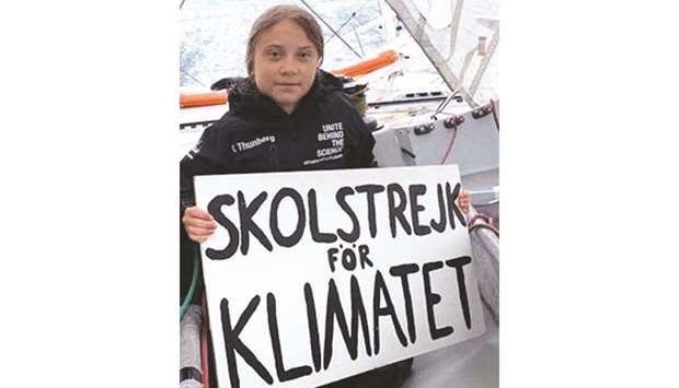 This picture released on Friday shows Thunberg holding a placard reading u2018School strike for climateu2019, aboard the Malizia yacht that will transport her across the Atlantic for the UN Climate Action Conference.