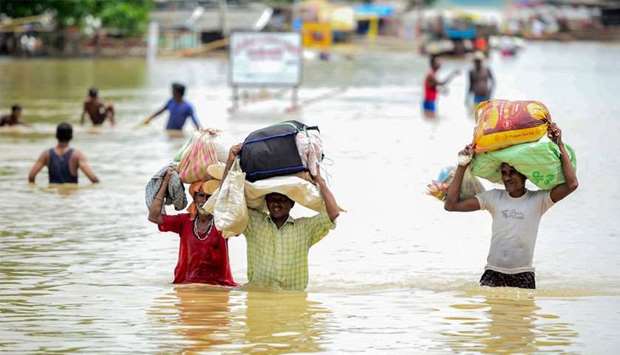 Flood-affected residents of a low lying area on the banks of the Ganges river move their belongings to drier ground at Sangam, as the water level of the Ganges and Yamuna rivers rises rapidly during monsoon rains in the region