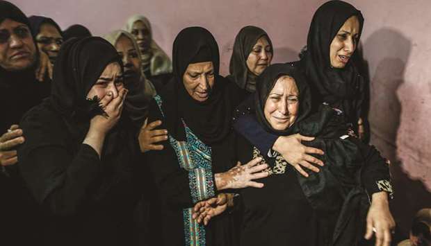 Relatives of 26-year-old Palestinian Mohamed Samir al-Taramsi, one of three Palestinians killed overnight in Israeli fire along the border with the Gaza Strip, mourn during his funeral in Beit Lahya in northern Gaza Strip, yesterday.
