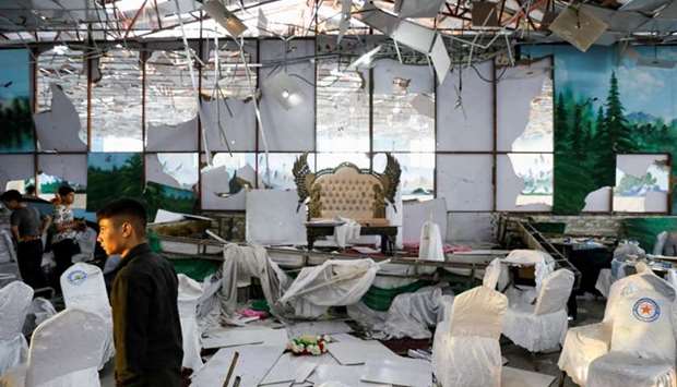 Workers of a wedding hall inspect after a blast in Kabul, Afghanistan