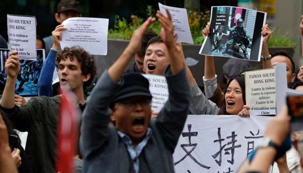 People hold placards reading ,Taiwan support Hong-Kong, and ,support Democracy, Freedom, and Human Rights, during a demonstration to support pro-democracy demonstrators in Hong Kong on the Place Saint-Michel in Paris, on Saturday.