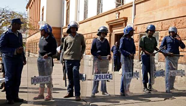 Riot police officers keep watch outside the Tredgold Building Magistrate court in Bulawayo, Zimbabwe