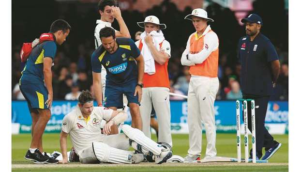 Australiau2019s Steve Smith (second from left) lays on the pitch after being hit in the neck off the bowling of Englandu2019s Jofra Archer (not pictured) on the fourth day of the second Test in London on Saturday. (AFP)