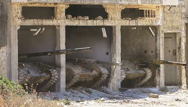 Syrian government tanks are seen parked near the town of Khan Sheikhun in the southern countryside of the rebel-held Idlib province.