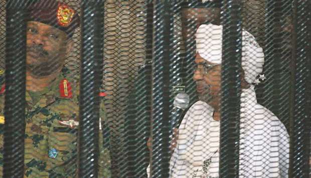 Omar al-Bashir stands in a defendantu2019s cage during the opening of his corruption trial in Khartoum yesterday.