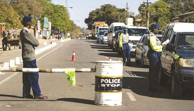 Police officers conduct searches on vehicles along a major road leading into Bulawayo yesterday.