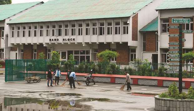 Workers clean the campus of a closed school in Srinagar yesterday.