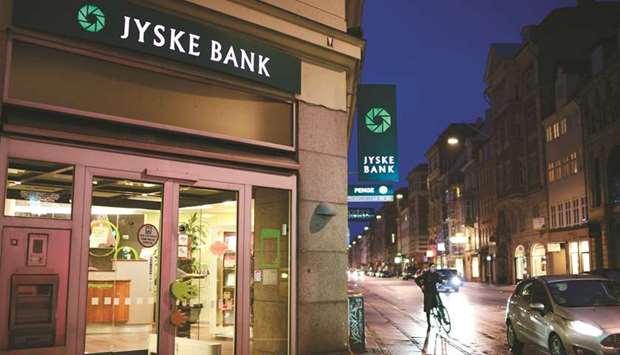 Signs are illuminated at night outside a Jyske Bank branch in Copenhagen.