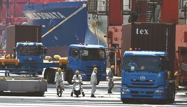 Trucks are seen transporting containers from a pier in Tokyou2019s port.
