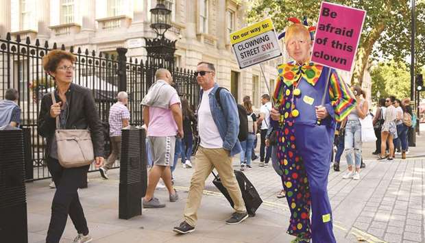 A demonstrator, dressed as a clown, protests in London.