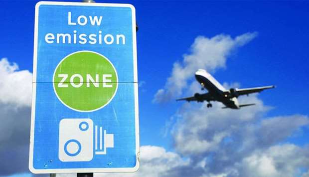 An aircraft operated by British Airways passes a low emission zone sign as it prepares to land at Heathrow airport in London. Shell, British Airways and Velocys have applied for the planning permission from local authorities in North East Lincolnshire in the UK to build a plant to produce jet fuel from domestic and commercial waste.