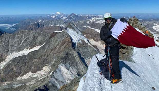 Qatari adventurer Fahad Badar poses with the national flag
