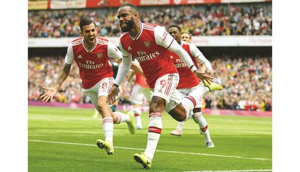 Arsenalu2019s French striker Alexandre Lacazette (centre) celebrates after scoring the opening goal of the English Premier League against Burnley at the Emirates Stadium in London on August 17, 2019. (AFP)