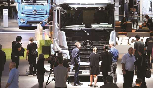 Visitors surround an Actros truck of German truck maker Mercedes-Benz at the IAA truck trade fair in Hanover, Germany. Daimler plans to build Mercedes-Benz-branded heavy trucks in China by revamping truck plants owned by its local joint venture, according to sources.