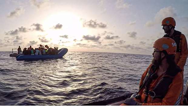Members of the German migrant rescue charity NGO Sea-Eye helping people to get off from an overloaded rubber boat spotted in international waters off the Libyan coast to bring them to their vessel ,Alan Kurdi,.