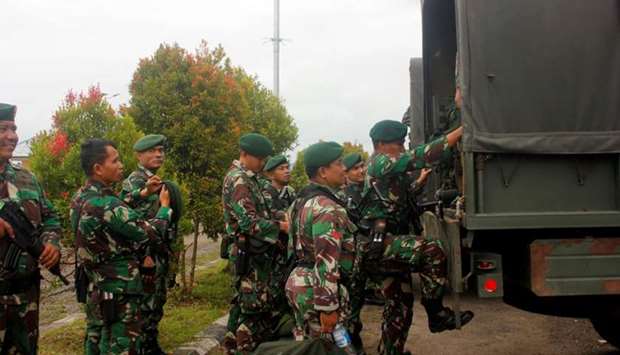 Indonesian soldiers get on to the vehicle as they arrive at Domine Eduard Osok Airport to be deployed to Sorong and Manokwari following the protests in Sorong, West Papua, Indonesia, yesterday