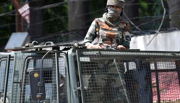 An Indian army soldier stands alert in a truck while travelling in a convoy in Srinagar on Sunday.
