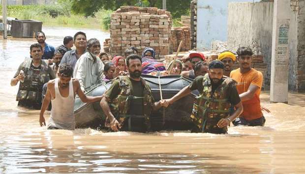 Army personnel rescue residents in a rubber boat following flooding in Kang Khurd, some 40km from Kapurthala in Punjab.