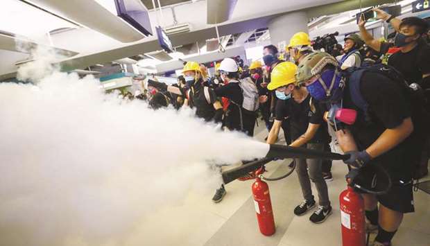 Protesters fire nitrogen extinguishers toward riot police during a standoff at Yuen Long MTR station, in Yuen Long, New Territories, Hong Kong, yesterday.