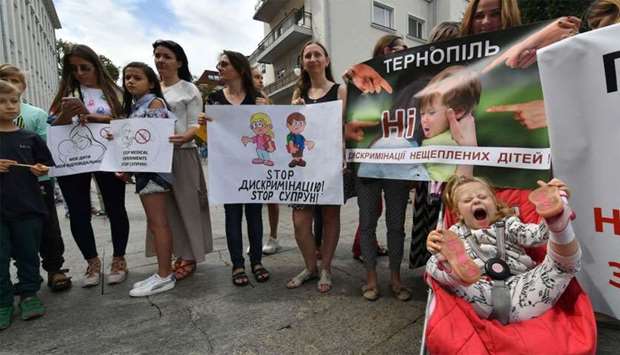 Activists and their children hold placards reading ,Demand equal access to education,, ,Stop discrimination,, ,To take away the right for education is a crime, and other slogans as they gathered in front of the Ukrainian President's office in Kiev