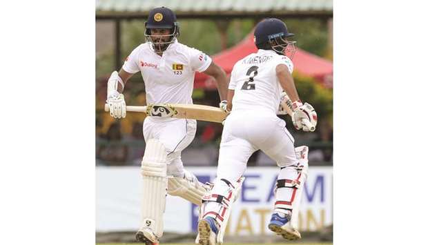 Sri Lankau2019s Dimuth Karunaratne (left) and teammate Kusal Mendis run between the wickets during the opening day of the final Test against New Zealand at the P. Sara Oval in Colombo yesterday. (AFP)
