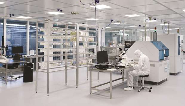 An employee carries out quality checks on light-emitting diode (LED) ceramic platelets inside the clean room at the Osram Licht lighting component manufacturing facility in Augsburg, Germany.
