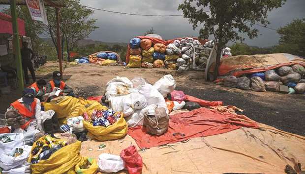 This picture taken on July 16, shows municipal workers in Islamabad sorting out recyclable items.