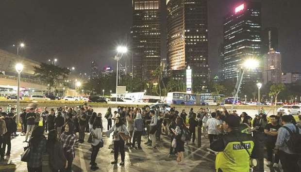 People gather outside an office building following an earthquake hit in Jakarta yesterday.