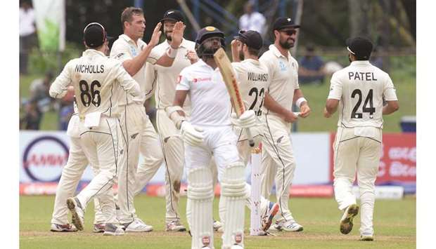 New Zealandu2019s Tim Southee (second from left) celebrates with his teammates after taking the wicket of Sri Lankau2019s Niroshan Dickwella (foreground) on the second day of the second Test at P. Sara Oval in Colombo yesterday. (AFP)