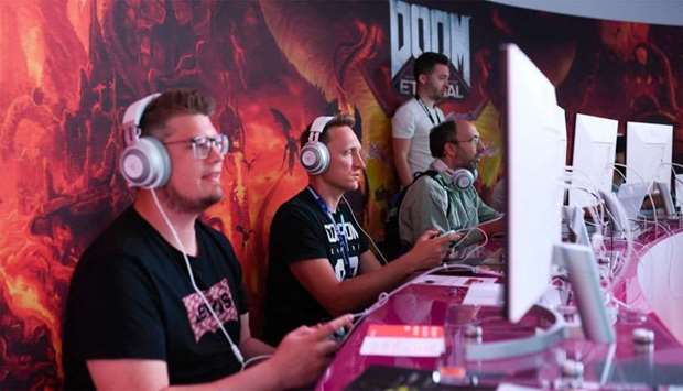 Visitors play the cloud-game based ,Doom, at the stand of Google Stadia during the Video games trade fair Gamescom in Cologne
