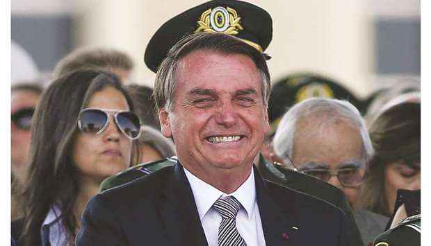 Brazilian President Jair Bolsonaro receives military honours during a ceremony for the Soldier Day at the Brazilian army headquarters in Brasilia yesterday. Bolsonaro says he is inclined to send the army to help fight fires in the Amazon.