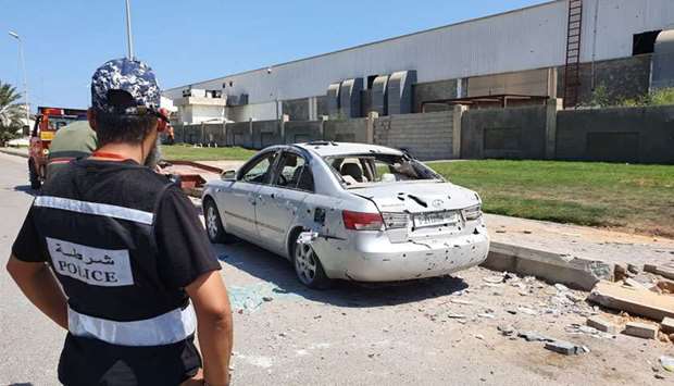 Libyan police inspects the damaged vehicles at the Mitiga International Airport in Libya's capital Tripoli