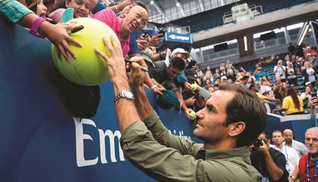 Roger Federer of Switzerland signs autographs after a press conference prior to the US Open at USTA Billie Jean King National Tennis Center in New York City.