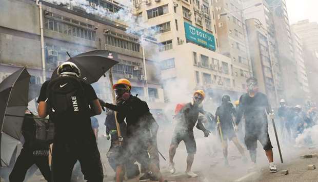 A demonstrator throws back a tear gas canister as they clash with riot police during a protest in Hong Kong yesterday.