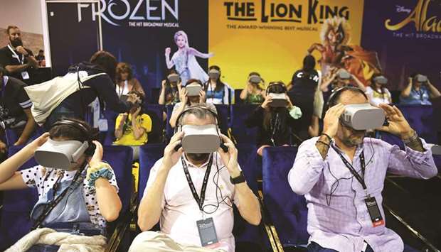Members of the audience try the Disney on Broadway virtual reality experience at the D23 Expo at the Anaheim Convention Center in Anaheim, California.