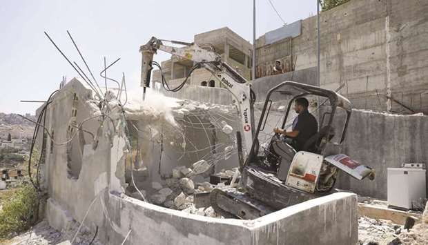 A relative of Mohamed Abbasi (not pictured), a Palestinian resident of Jerusalem, helps him demolish his home in east Jerusalem, yesterday. Complying to an Israeli court order which ruled that the house was built without a municipality permit, Abbasi decided to have his house demolished using a bulldozer that he hired in order to save on costs that would have been higher if a Israeli government bulldozer had carried out the demolition.