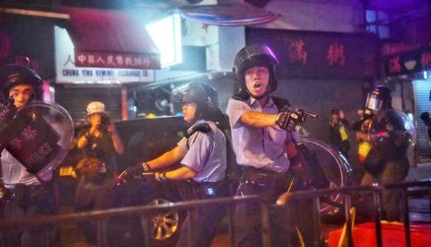 Police officers point their guns at protesters in Tseun Wan in Hong Kong. AFP
