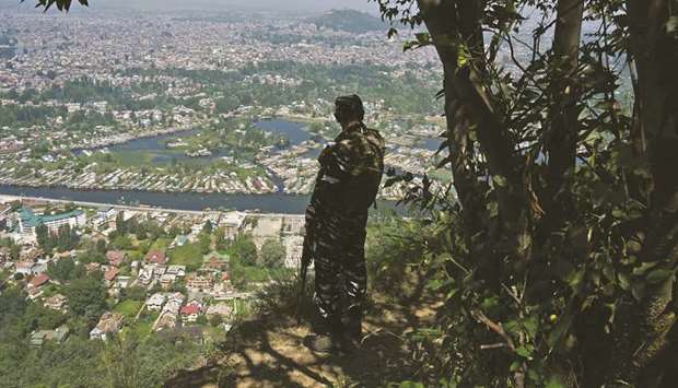 A paramilitary trooper patrols at the top of a hill in Srinagar yesterday.